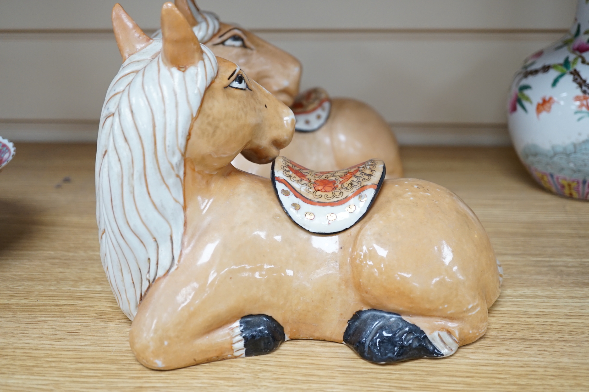 A pair of Chinese ceramic seated horses, 18cm high